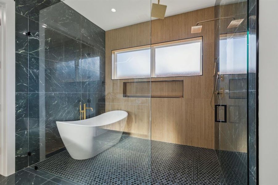 Bathroom featuring shower with separate bathtub and tile walls