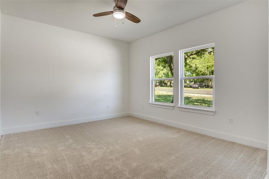 Spare room with light carpet and a ceiling fan Spare room with light carpet and a ceiling fan