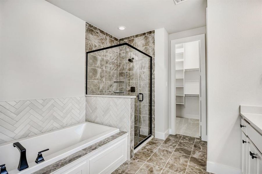 Bathroom with vanity, a bath, a shower stall, and a spacious closet