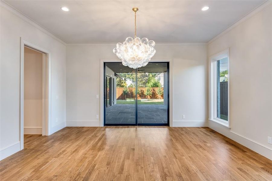 Unfurnished dining area featuring a chandelier, light wood-style flooring, ornamental molding, and recessed lighting Unfurnished dining area featuring a chandelier, light wood-style flooring, ornamental molding, and recessed lighting