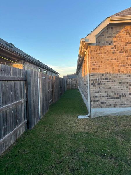 The property features a brick exterior with gutters and a well-maintained lawn