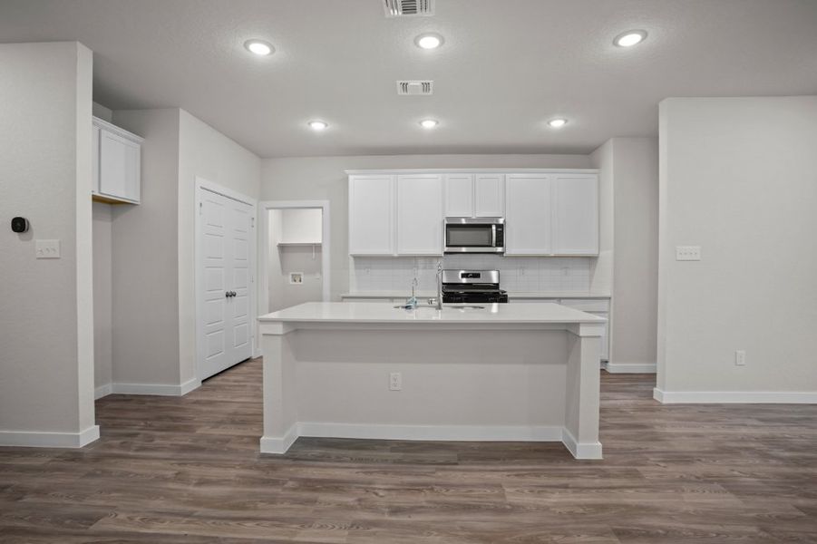 A kitchen with white cabinets.