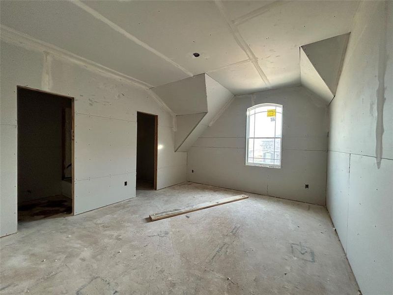 One of the three upstairs bedrooms is empty, featuring simple walls and large windows that fill the room with natural light, ready to be personalized into a cozy retreat.