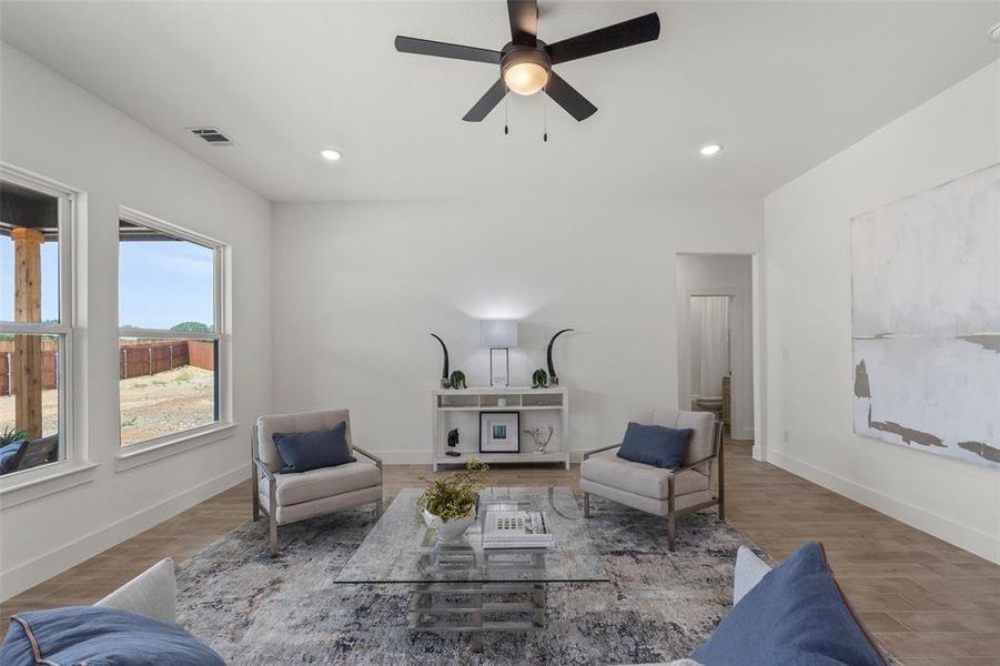 Living room featuring wood-type flooring and ceiling fan