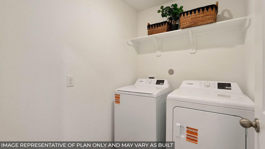 Dedicated laundry space featuring a white washer and dryer pair, white wall-mounted shelving, and neutral wall finishes