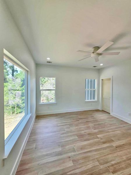 Empty room with healthy amount of natural light, light wood-style floors, recessed lighting, and ceiling fan