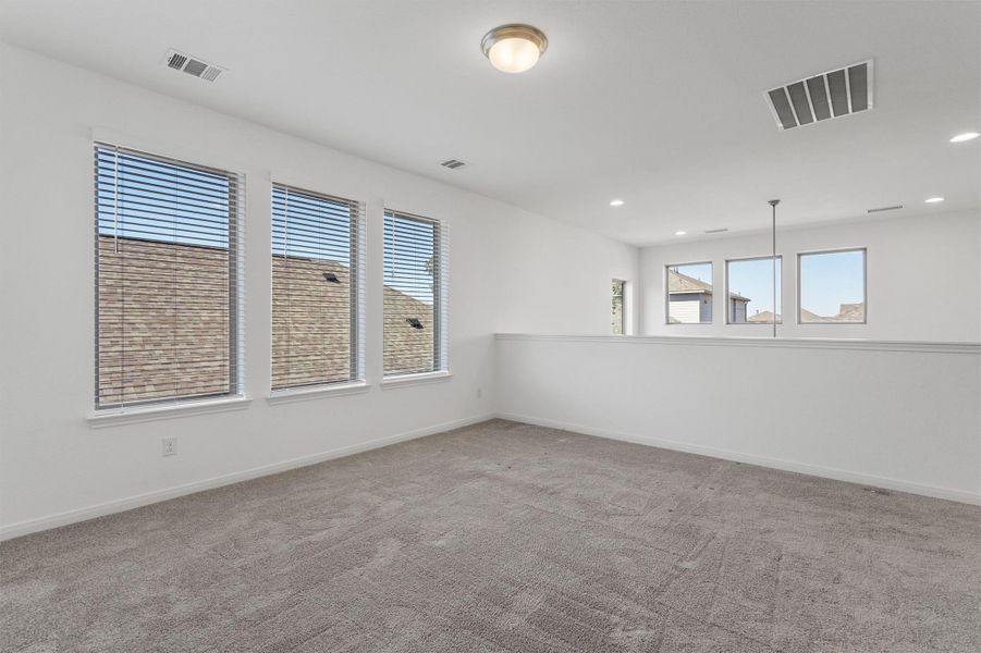 Carpeted spare room with baseboards and recessed lighting