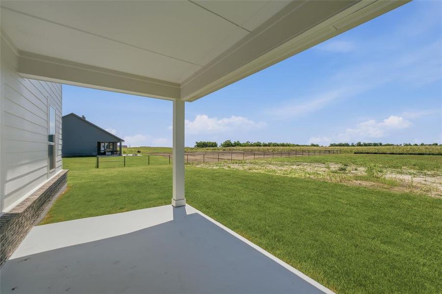 Covered patio featuring a concrete slab and white support columns Covered patio featuring a concrete slab and white support columns