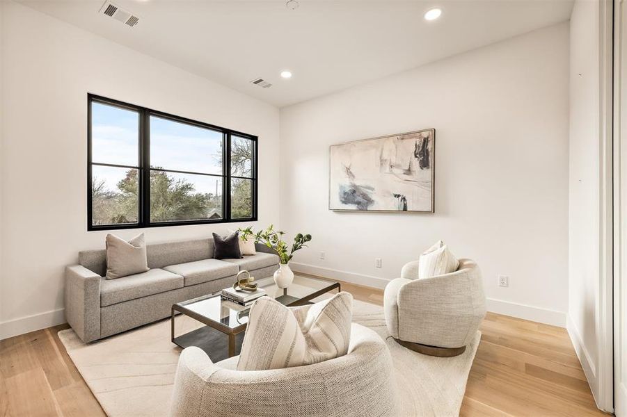 The upstairs living space offers a flexible area to relax, watch movies, or gather, providing a comfortable separation from the main level