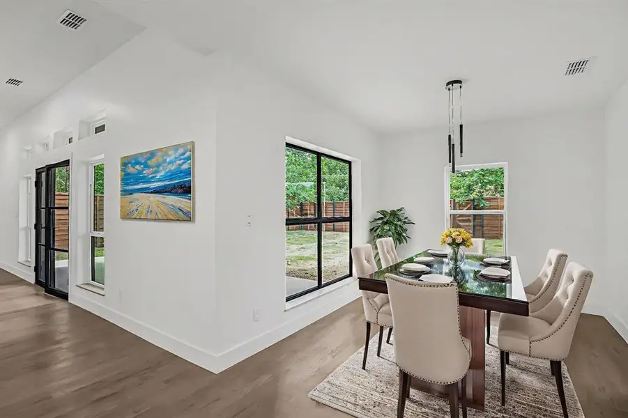 Dining space with dark wood-type flooring and baseboards Dining space with dark wood-type flooring and baseboards