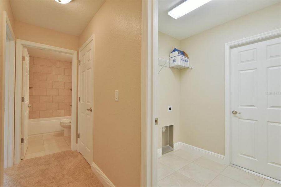 Hallway view of guest bath and inside laundry