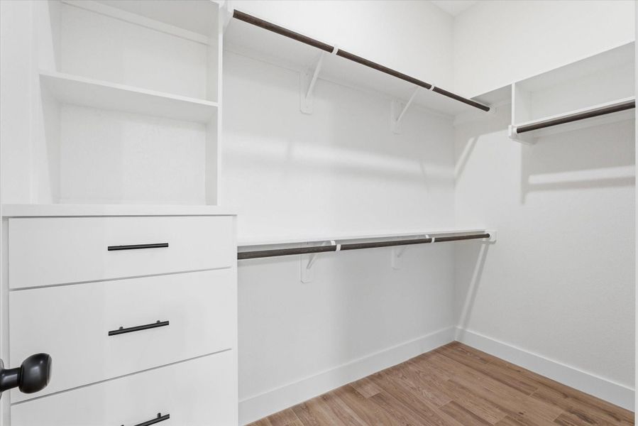 Enjoy a generous walk-in closet in the primary bedroom, thoughtfully designed with custom shelving and built-in drawers. Enjoy a generous walk-in closet in the primary bedroom, thoughtfully designed with custom shelving and built-in drawers.