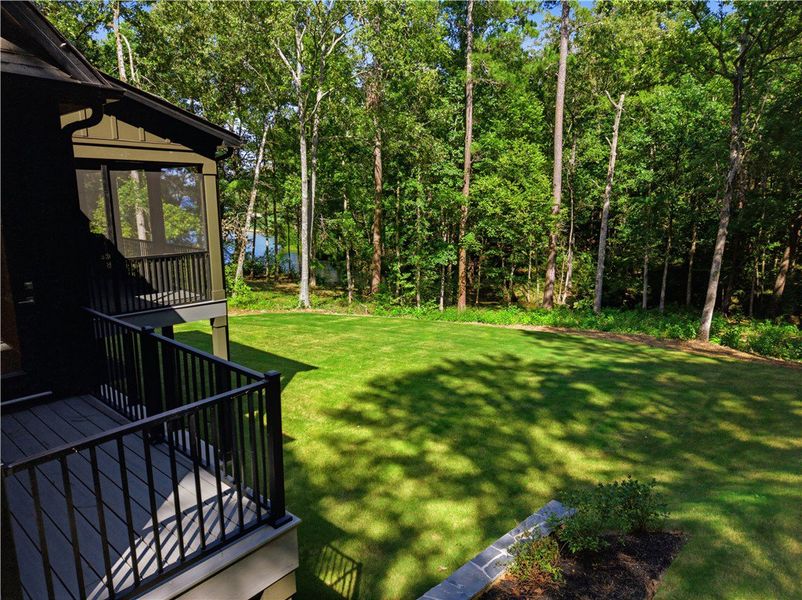 Mature trees frame a rolling green lawn bordered b