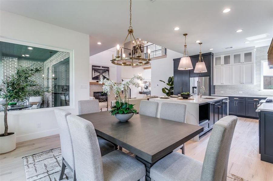 Dining area featuring a notable chandelier, sink, and light hardwood / wood-style flooring