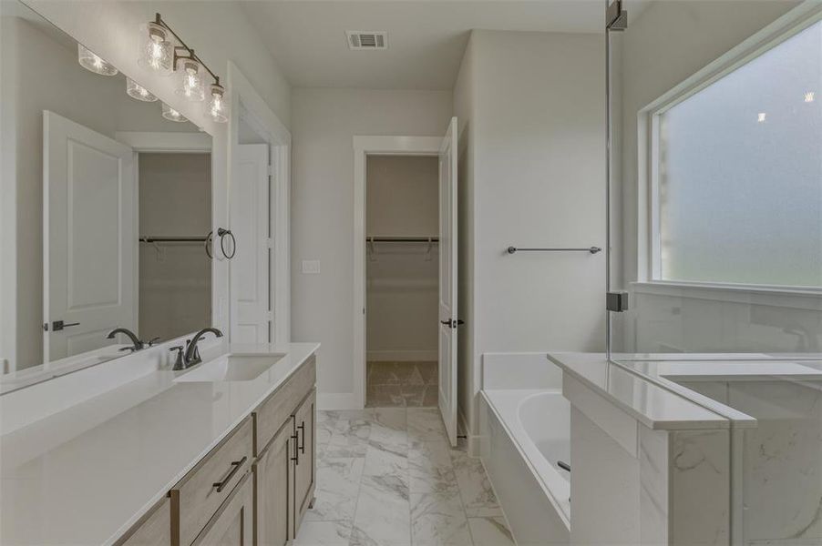 Bathroom featuring a double vanity with stone countertops, undermount sinks, and matte black fixtures Bathroom featuring a double vanity with stone countertops, undermount sinks, and matte black fixtures