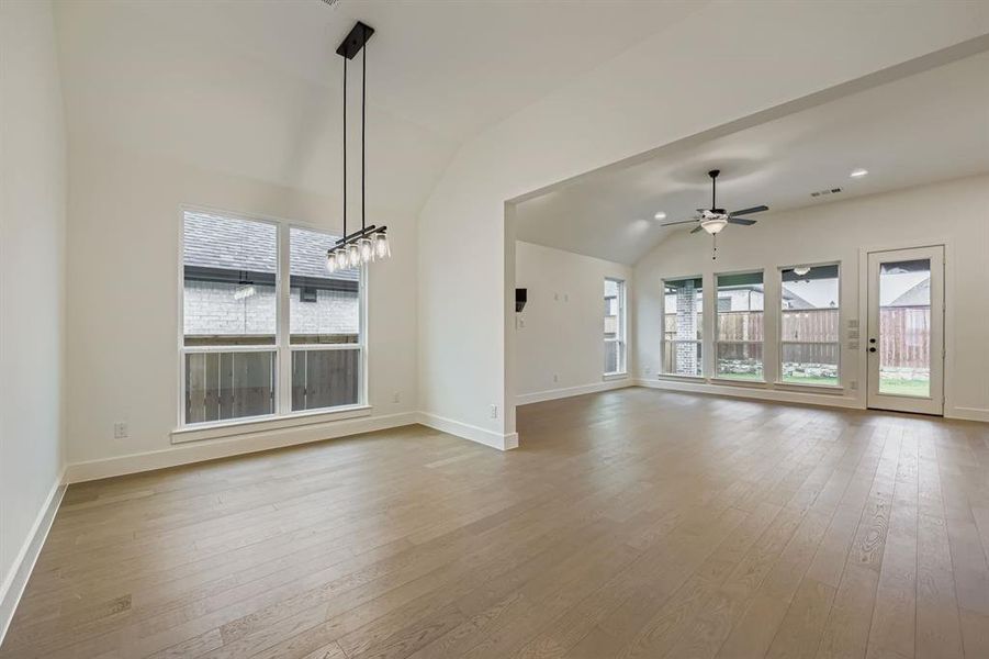 Unfurnished living room with vaulted ceiling, light wood-style floors, recessed lighting, and a ceiling fan