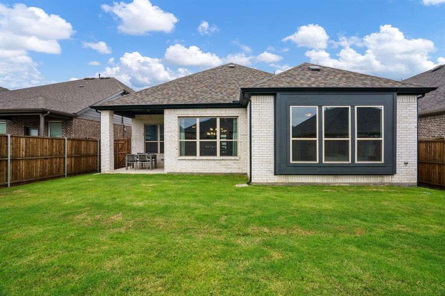 Rear view of house featuring brick siding, roof with shingles, and a patio area Rear view of house featuring brick siding, roof with shingles, and a patio area
