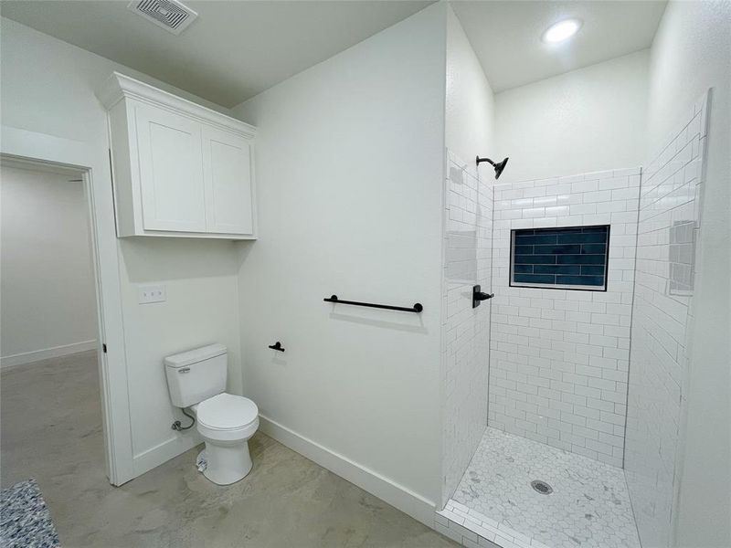 Bathroom featuring toilet and a tile shower