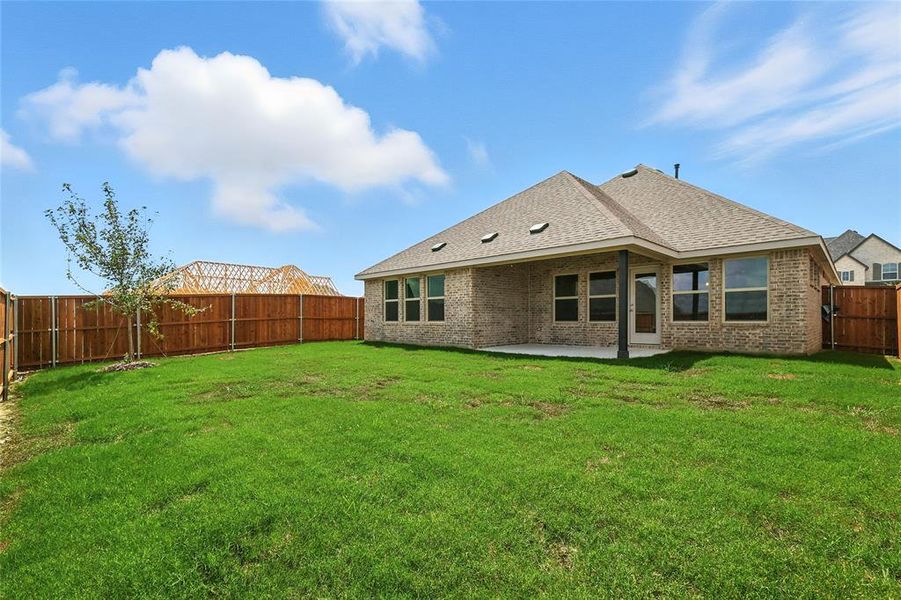 Rear view of house with a fenced backyard, a patio, roof with shingles, and brick siding Rear view of house with a fenced backyard, a patio, roof with shingles, and brick siding