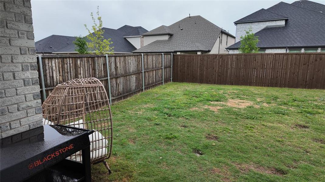 The property features a fenced backyard with a lawn