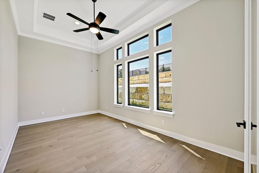 Natural light floods this spacious south facing bedroom, featuring an en-suite, elegant hardwood flooring and crown molding.