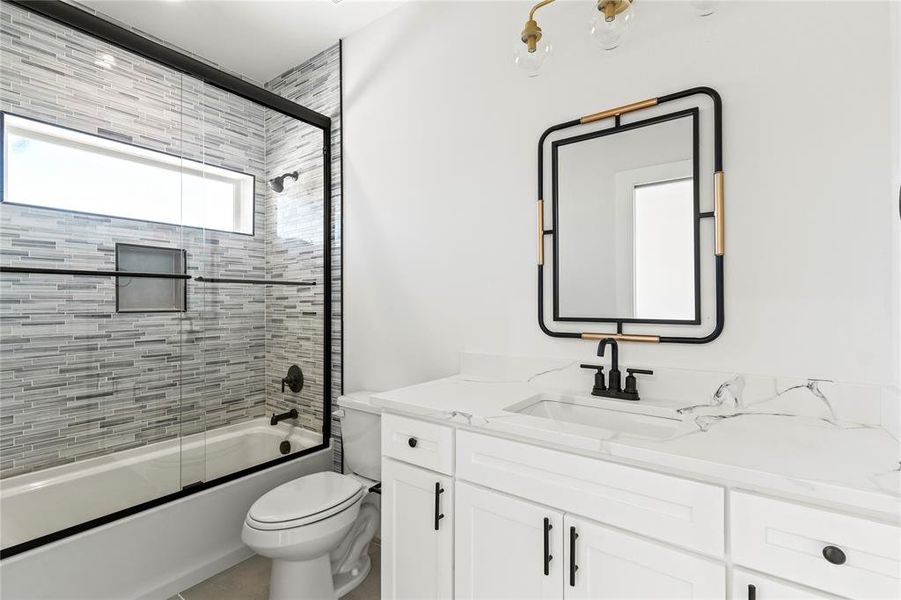 Bathroom featuring bath / shower combo with glass door and vanity Bathroom featuring bath / shower combo with glass door and vanity