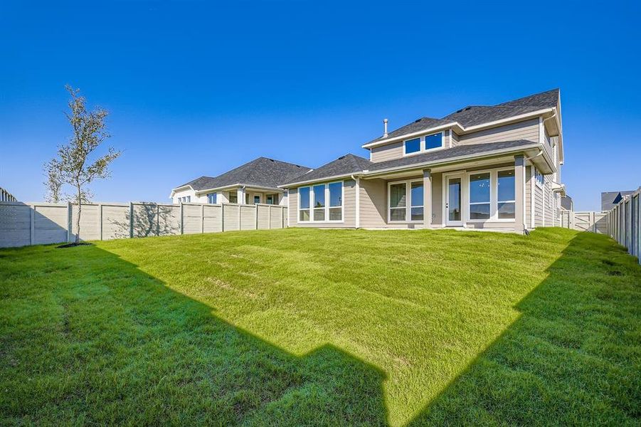 Rear view of house with a fenced backyard and a patio area