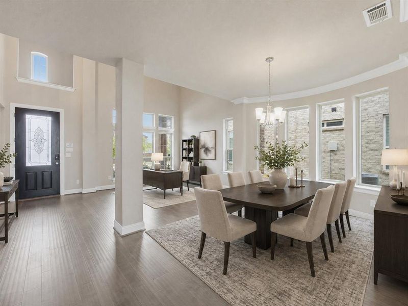 Spacious dining area featuring a contemporary chandelier, multiple windows, and crown molding