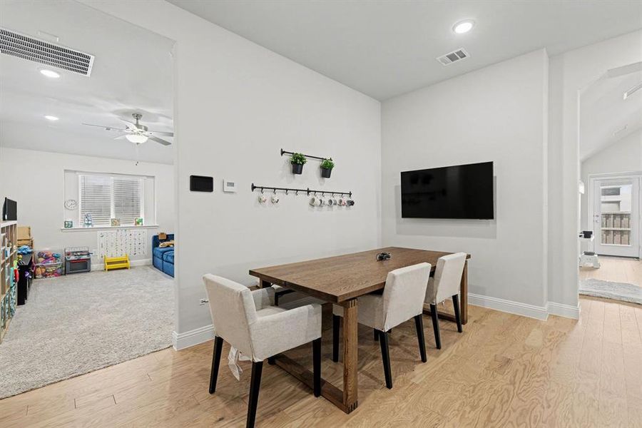 Hardwood-style flooring in a light finish, recessed lighting, and white baseboards
