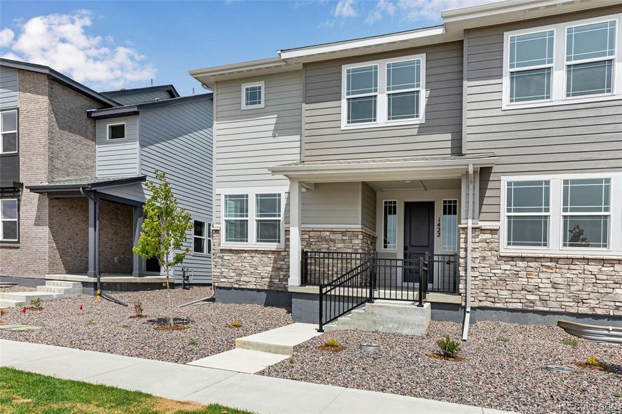 Front exterior of a new home in Sugar Mill Village, Longmont, CO, highlighting curb appeal (Image 1).