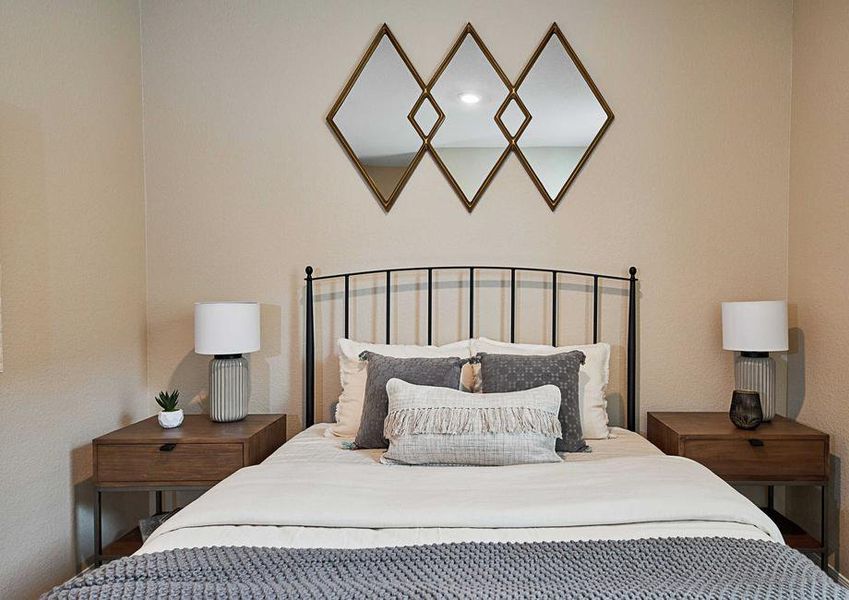 Staged bedroom with large bed, two nightstands, and wall decor.