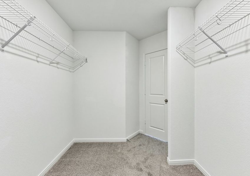 Walk-in closet featuring built-in wire shelving for storage.