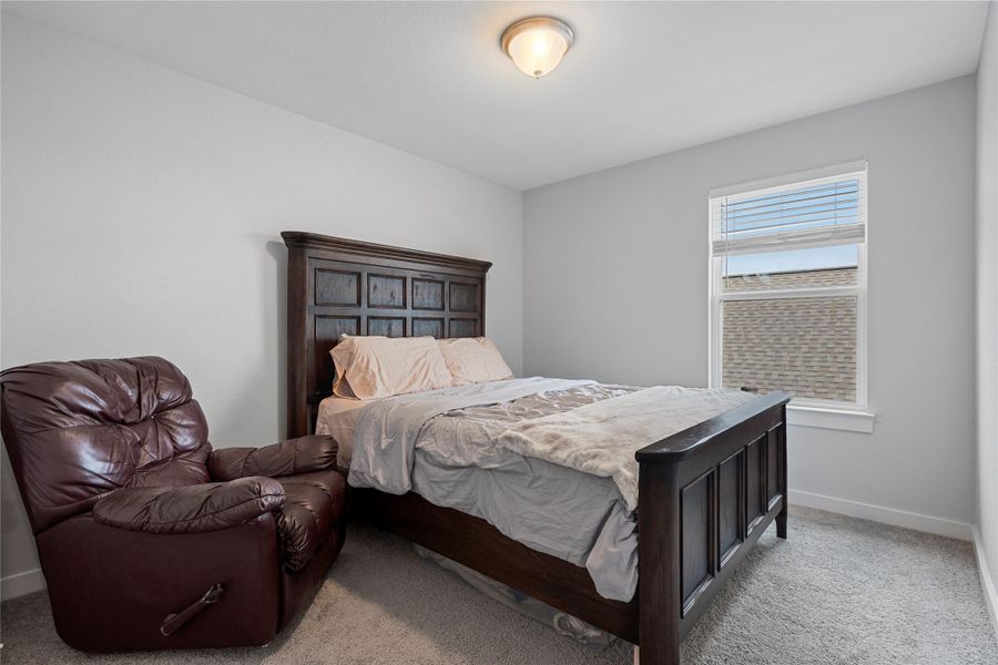 Bedroom featuring light carpet and baseboards Bedroom featuring light carpet and baseboards