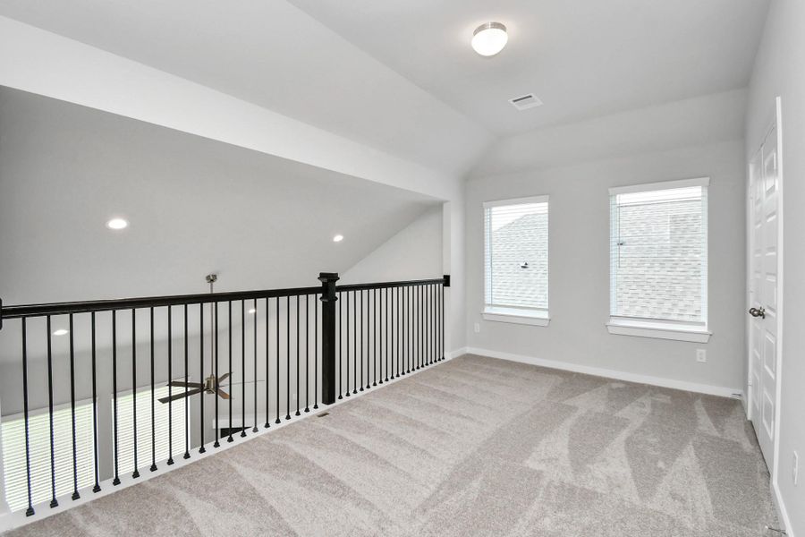 Ascend to relaxation in this fantastic game room! Ideal for both casual gatherings and adult gaming, it boasts plush carpet, lofty ceilings, custom paint, and ample windows for abundant natural light. Sample photo of completed home with similar floor plan. Actual colors and selections may vary.