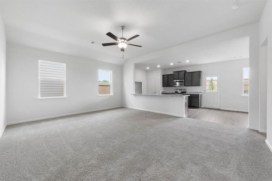 Living room featuring ceiling fan and light carpet