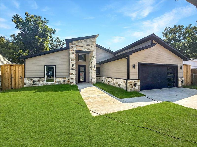 Contemporary home featuring stone siding, concrete driveway, and an attached garage