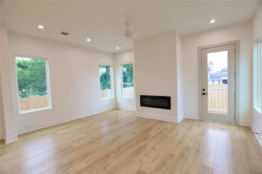 Your living room is complete with a remote-controlled fan, and to the right of the fireplace, you'll find a patio door leading to your spacious backyard Your living room is complete with a remote-controlled fan, and to the right of the fireplace, you'll find a patio door leading to your spacious backyard