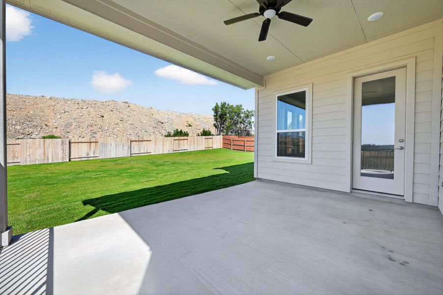 Fenced backyard featuring a ceiling fan, a patio, and a mountain view