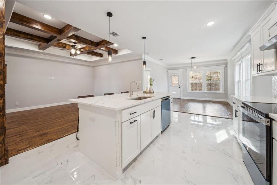 Kitchen with white cabinetry, an island with sink, decorative light fixtures, dishwasher, and sink