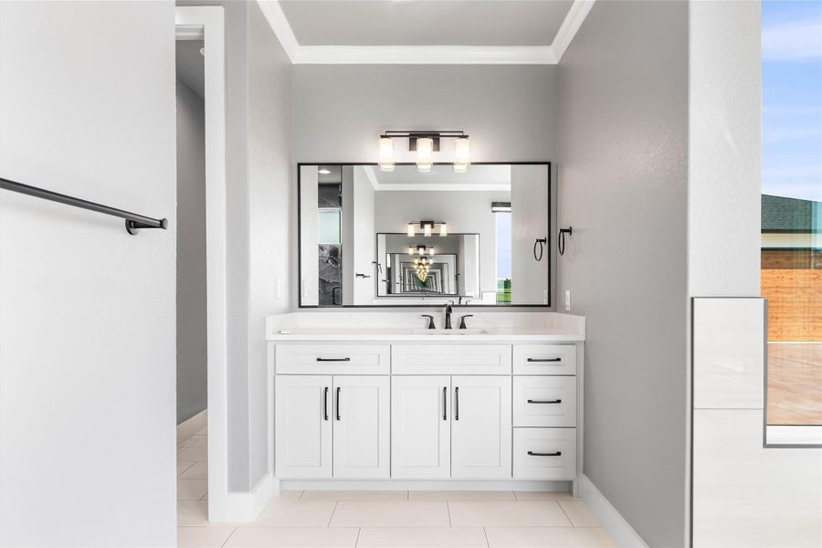 Bathroom featuring ornamental molding, vanity, baseboards, and tile patterned floors Bathroom featuring ornamental molding, vanity, baseboards, and tile patterned floors