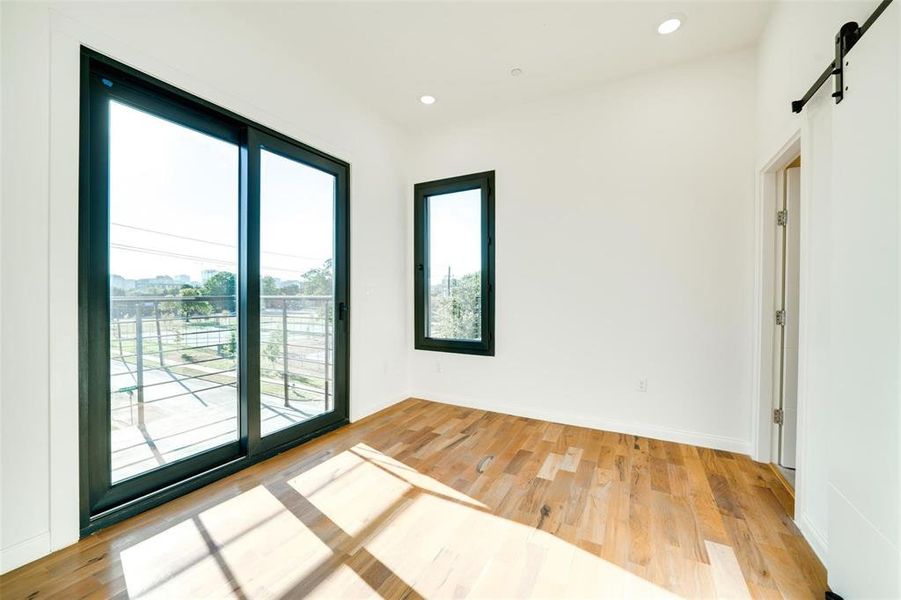 Spare room with light hardwood / wood-style floors and a barn door