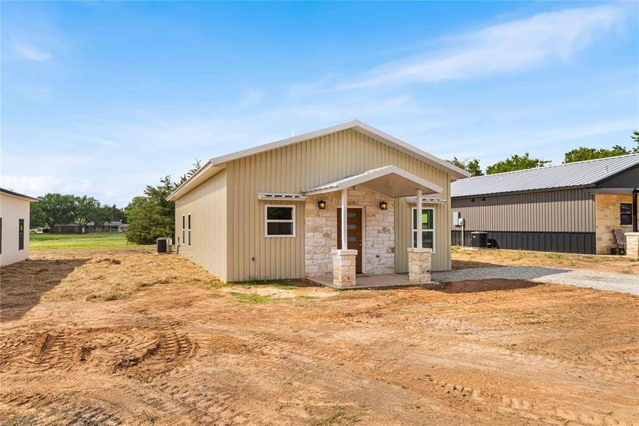 View of front facade featuring central AC unit and stone siding View of front facade featuring central AC unit and stone siding