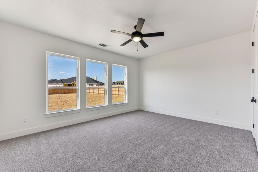 Unfurnished room with light colored carpet and ceiling fan