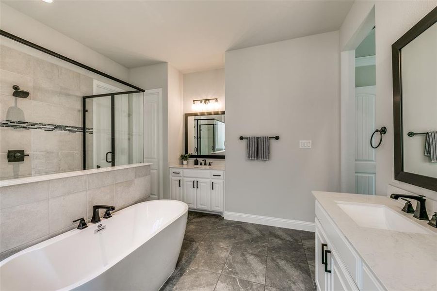 Bathroom with tile flooring, shower with separate bathtub, and vanity