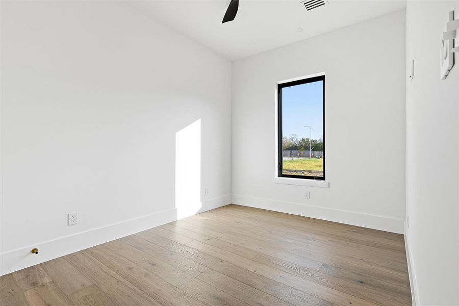 Same floorplan - different finishes. Another bedroom demonstrating the clean lines of the interior architecture and the high-efficiency black-framed windows.