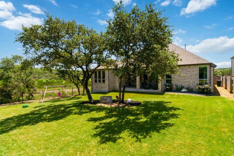 A verdant lawn extends from a brick residence, offering ample outdoor leisure space.