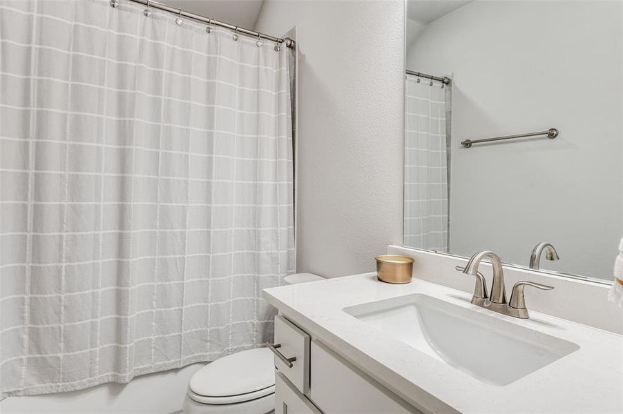 Full bathroom featuring shower / tub combo, toilet, and vanity