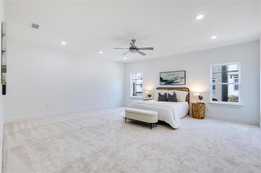 Bedroom with ceiling fan and light colored carpet