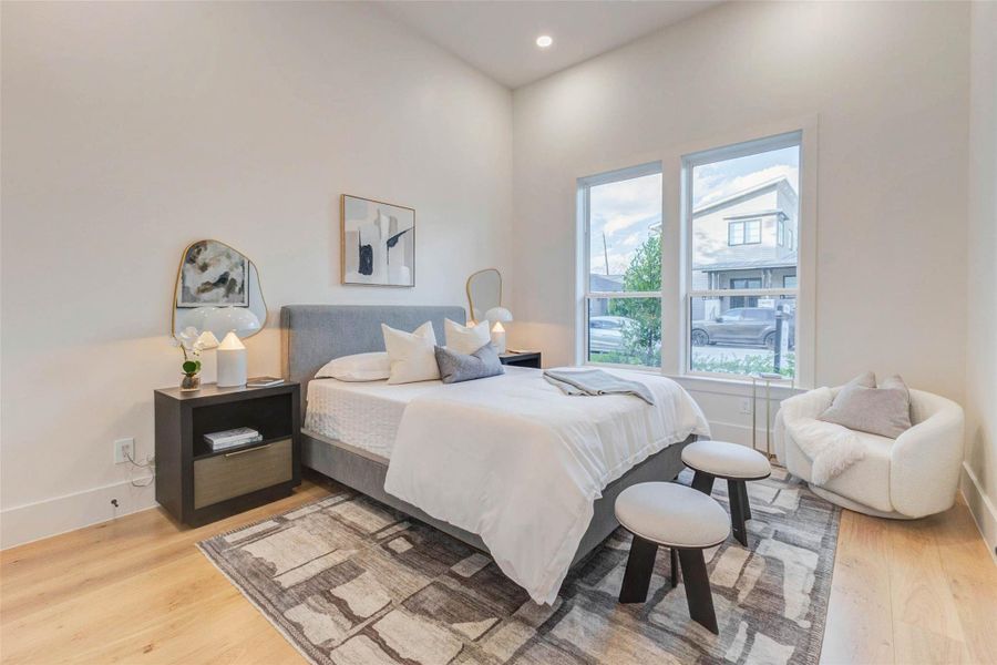 Bright first-floor guest suite with wide-plank hardwood floors and large front windows overlooking the landscaped yard. A perfect retreat for guests or a flexible home office option.