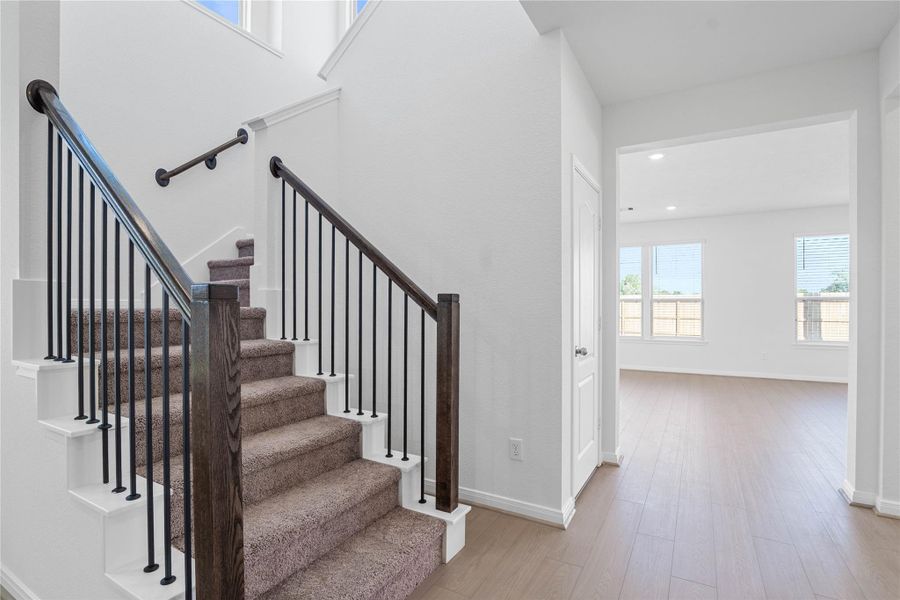 An elegant staircase makes a striking first impression, featuring the timeless combination of rich wood handrails and classic wrought iron balusters. An elegant staircase makes a striking first impression, featuring the timeless combination of rich wood handrails and classic wrought iron balusters.